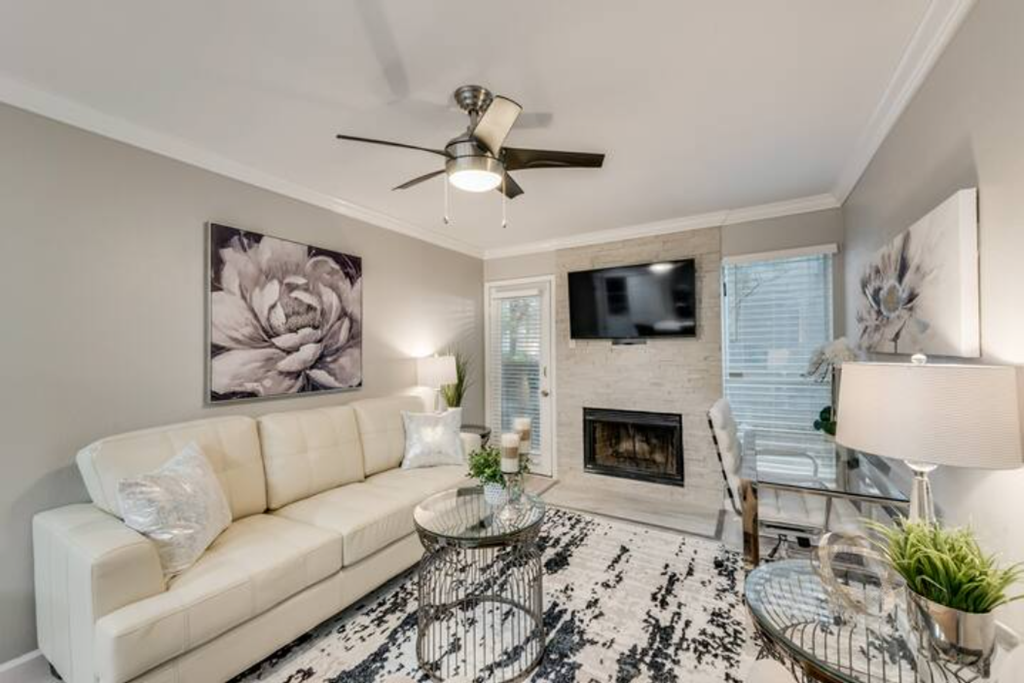 a living room with a white couch and a ceiling fan