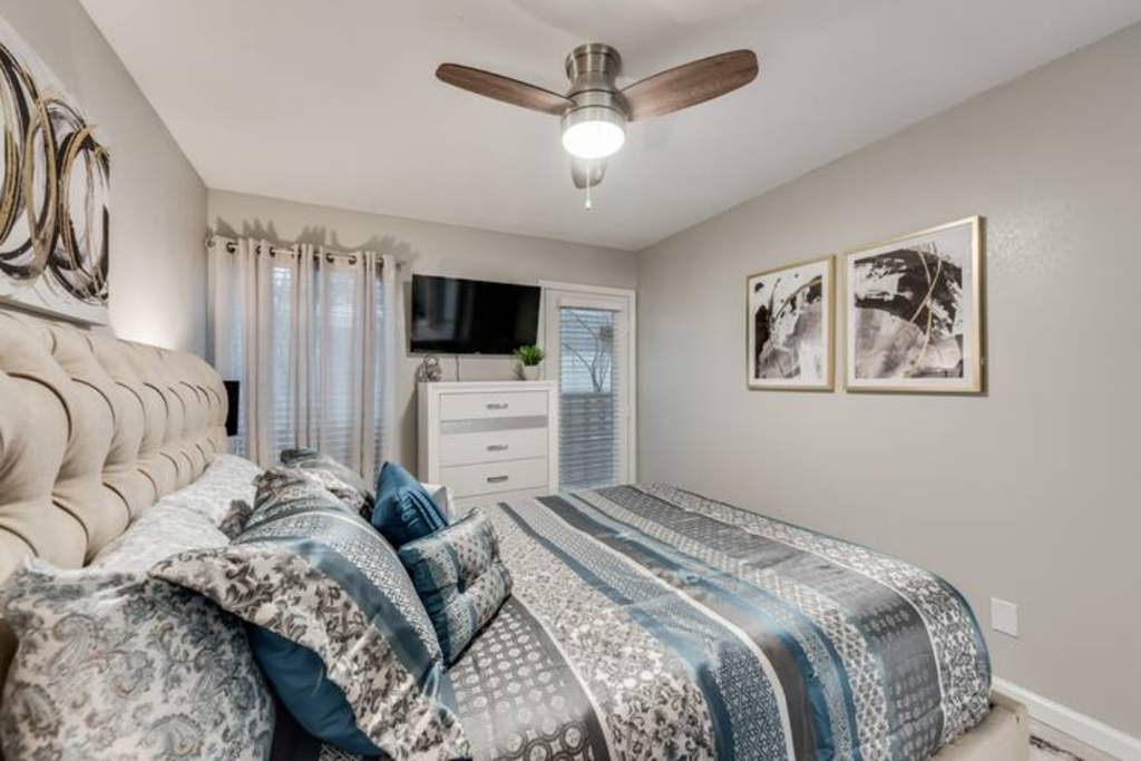 a bedroom with a bed and a ceiling fan