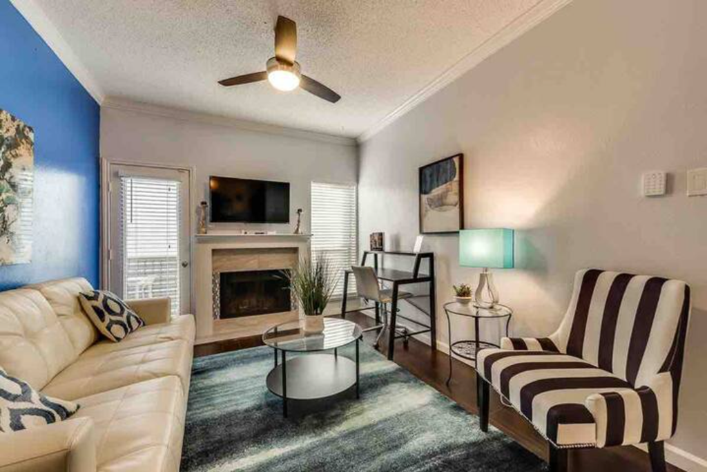 a living room with a couch and a chair and a fireplace