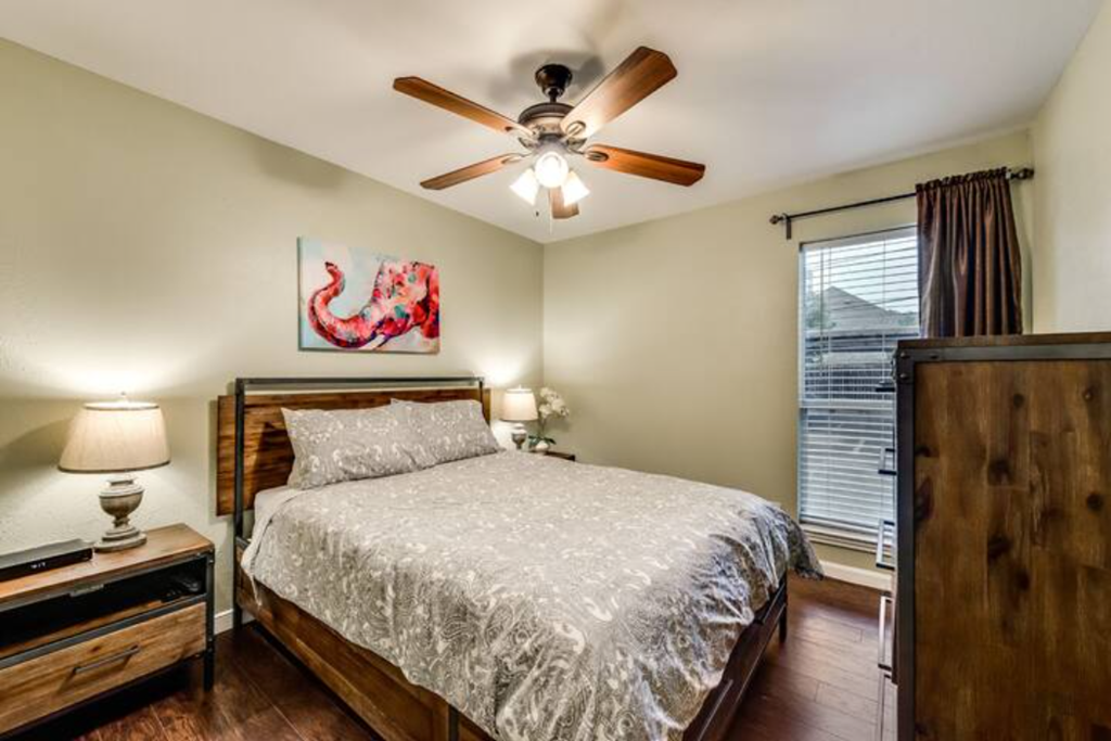a bedroom with a ceiling fan and a bed