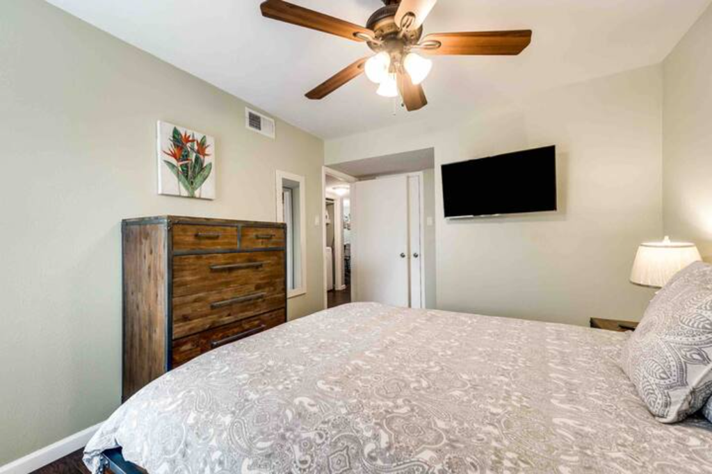 a bedroom with a large bed and a ceiling fan