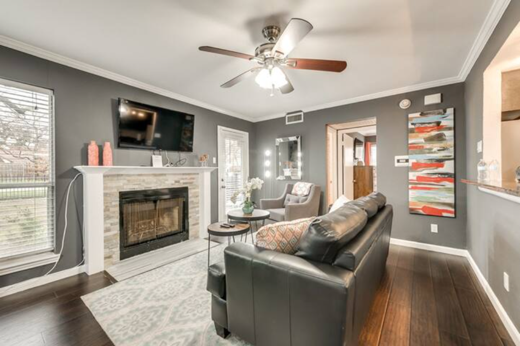 a living room with a leather couch and a fireplace