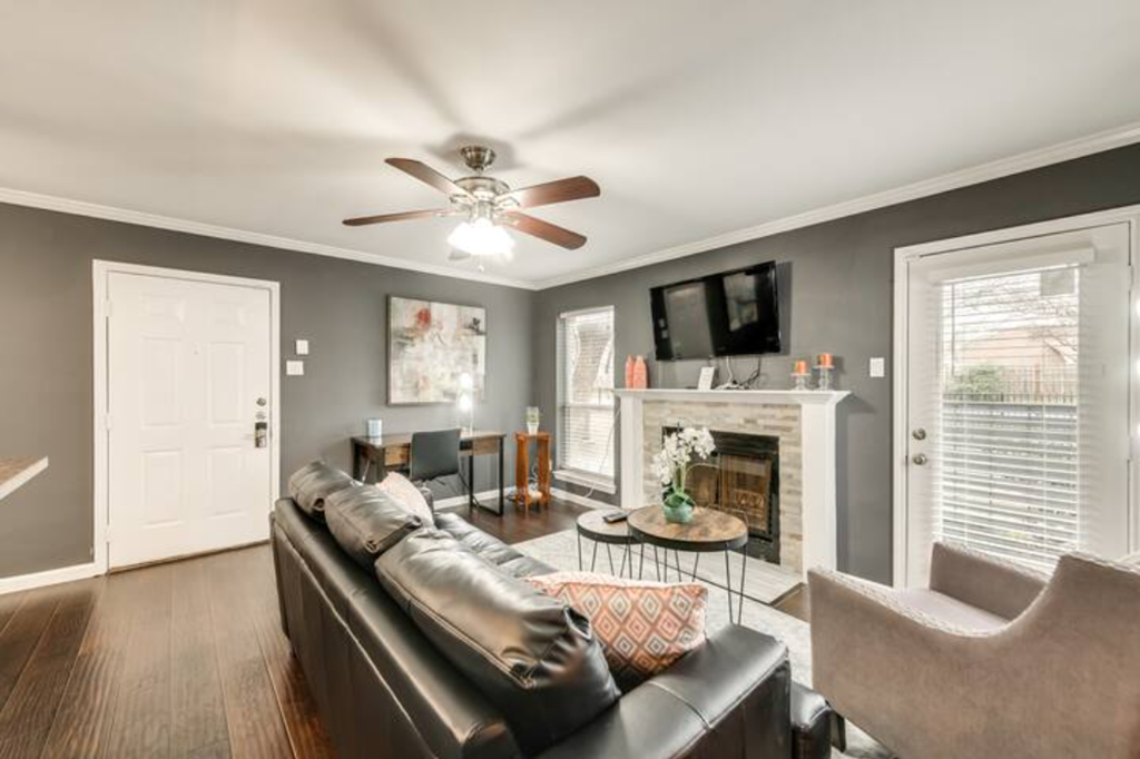 a living room with a leather couch and a ceiling fan