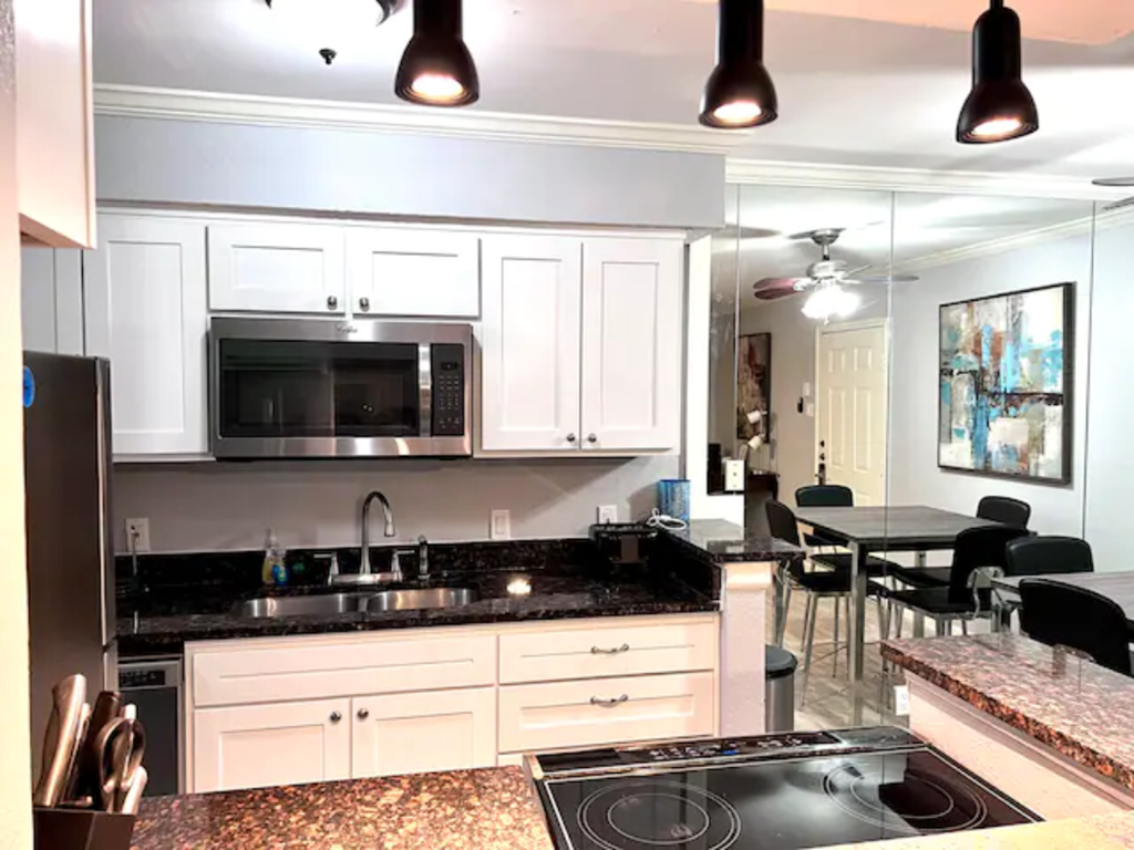 a kitchen with white cabinets and a stove and a microwave