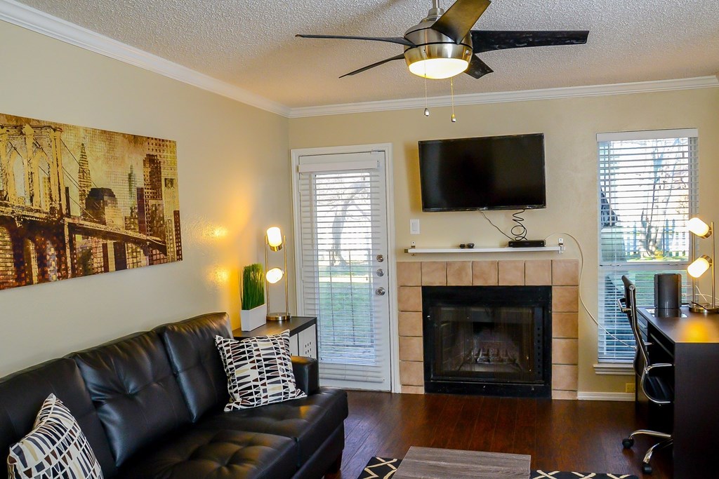 a living room with a leather couch and a fireplace