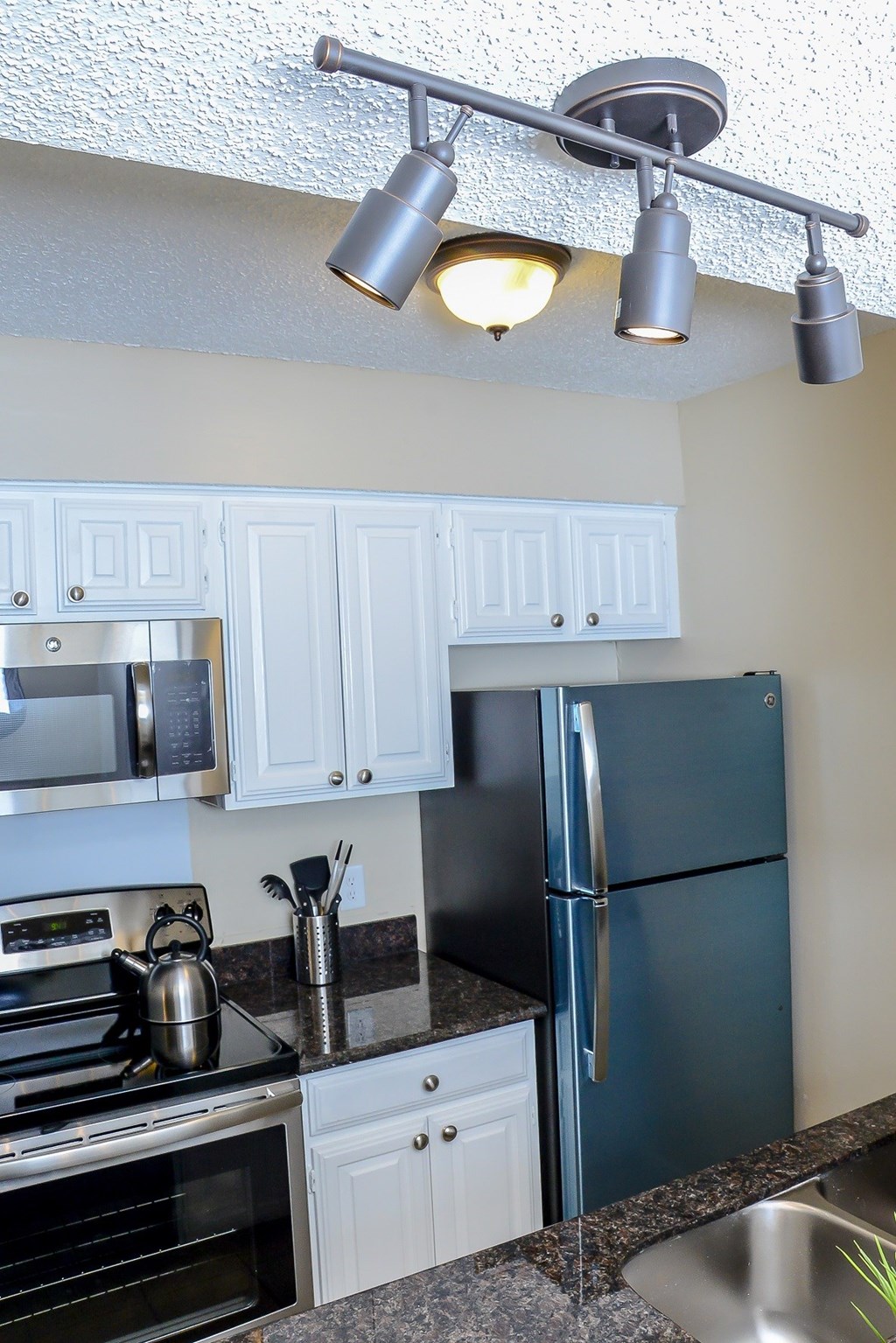 a kitchen with stainless steel appliances and white cabinets