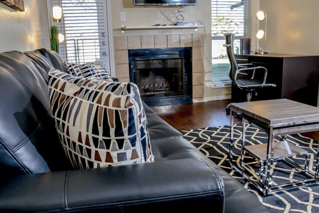 a living room with a leather couch and a fireplace