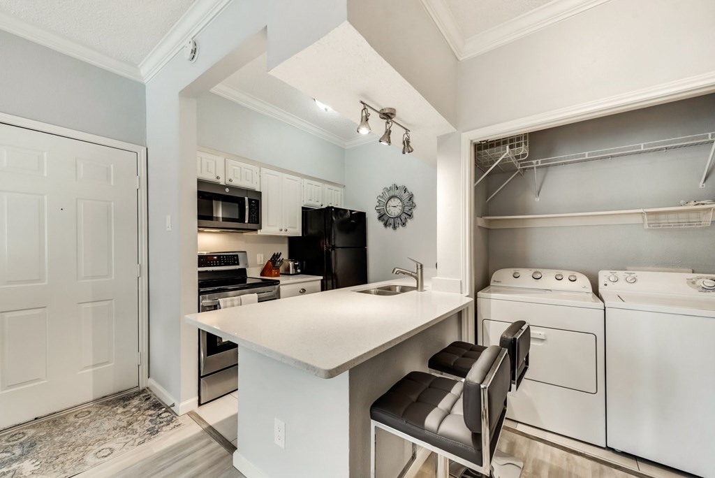 a kitchen with a white counter top and a white stove and refrigerator
