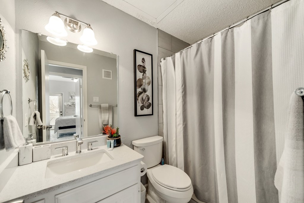a bathroom with a shower and a sink and a toilet