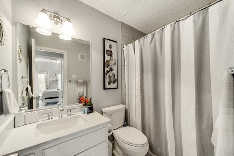 a bathroom with a shower and a sink and a toilet