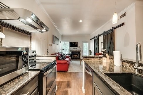 a kitchen with granite counter tops and a living room