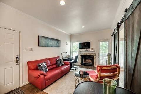 a living room with a red couch and a fireplace