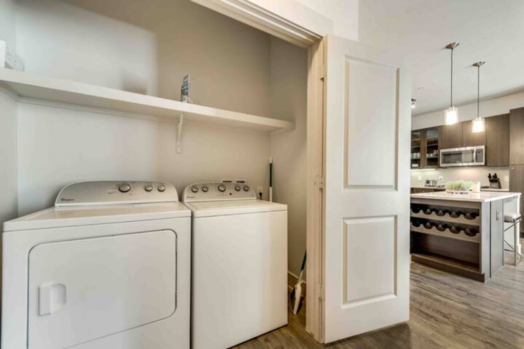 a white washer and dryer in a room with a kitchen