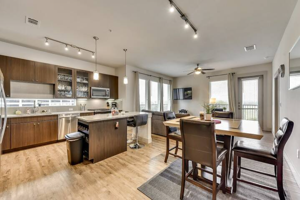 a kitchen and living room with a table and chairs