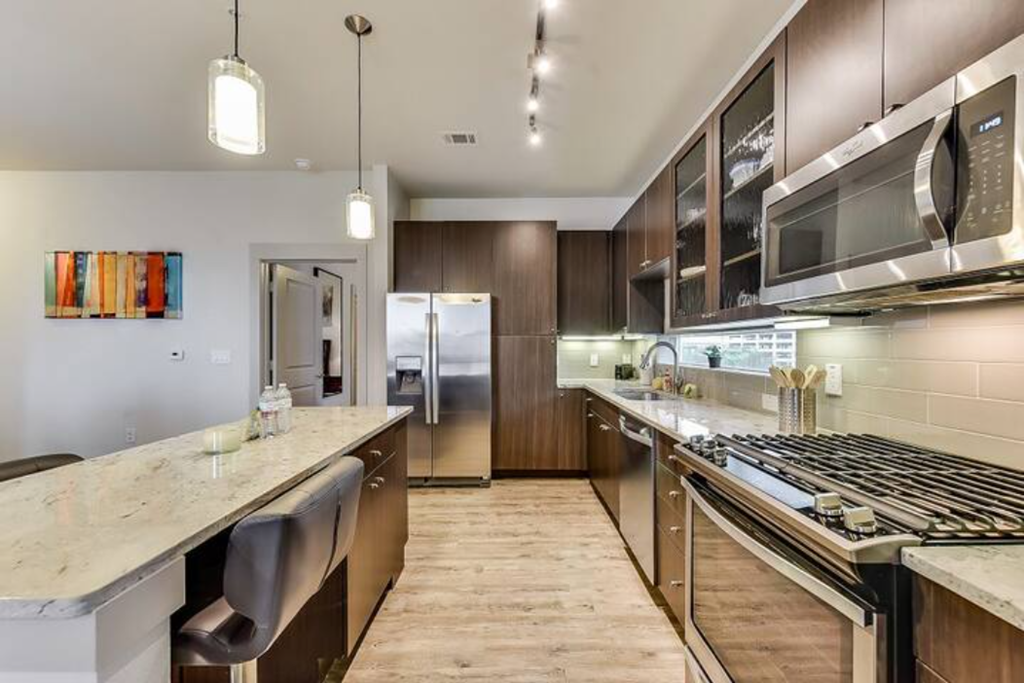 a large kitchen with stainless steel appliances and marble counter tops