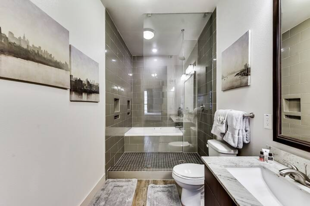 a bathroom with a shower and a toilet and a sink