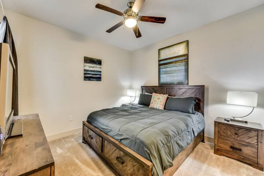 a bedroom with a bed and a ceiling fan