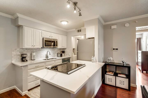 a white kitchen with a stove and a refrigerator