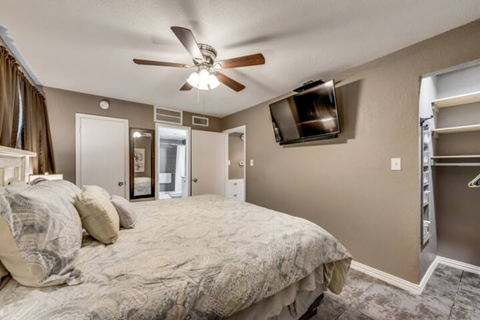 a bedroom with a large bed and a ceiling fan
