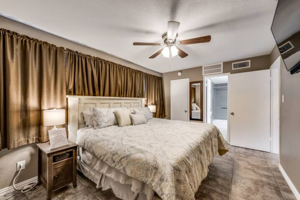 a bedroom with a large bed and a ceiling fan