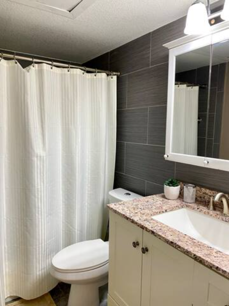 a bathroom with a toilet and a sink and a shower