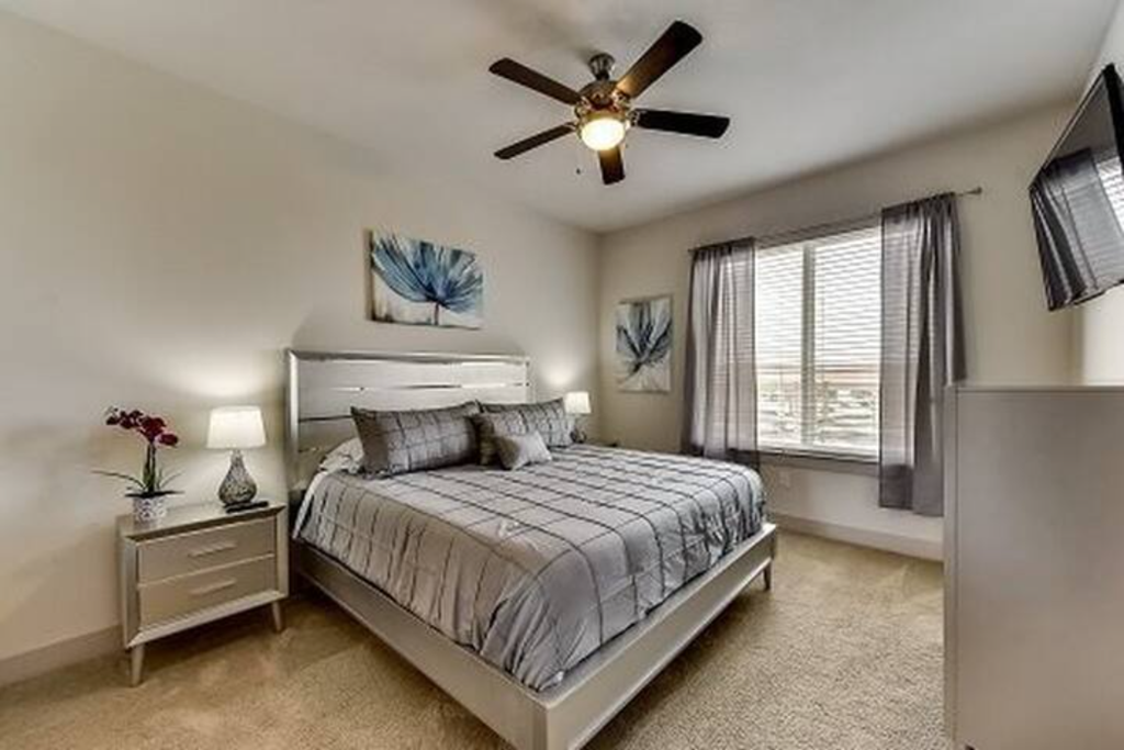 a bedroom with a bed and a ceiling fan