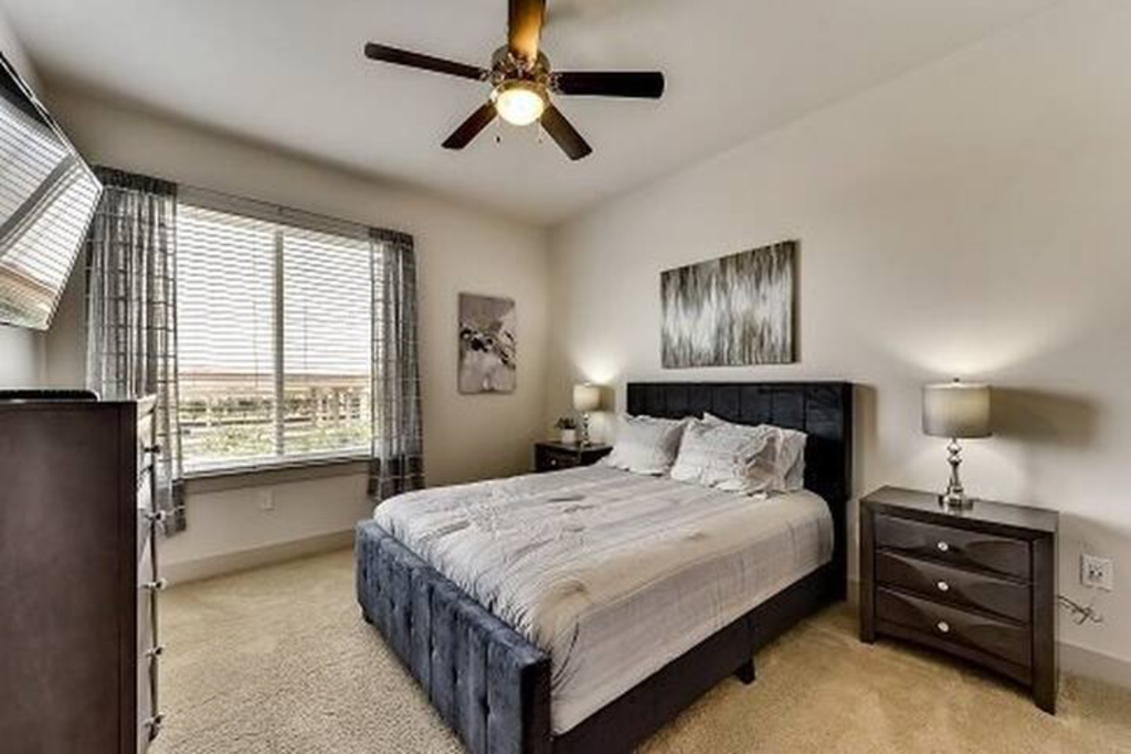 a bedroom with a bed and a ceiling fan