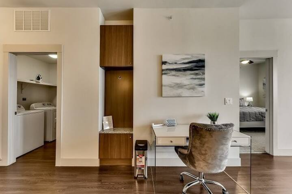 a living room with a desk and a chair