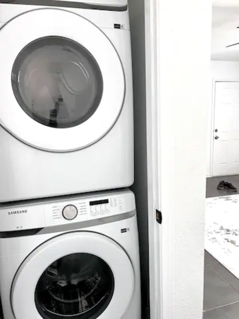 a white washer and dryer in a white laundry room