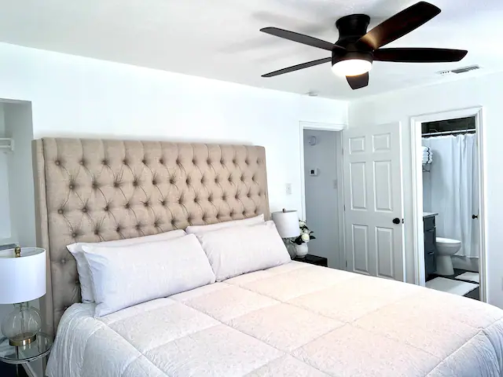 a bedroom with a large bed and a ceiling fan