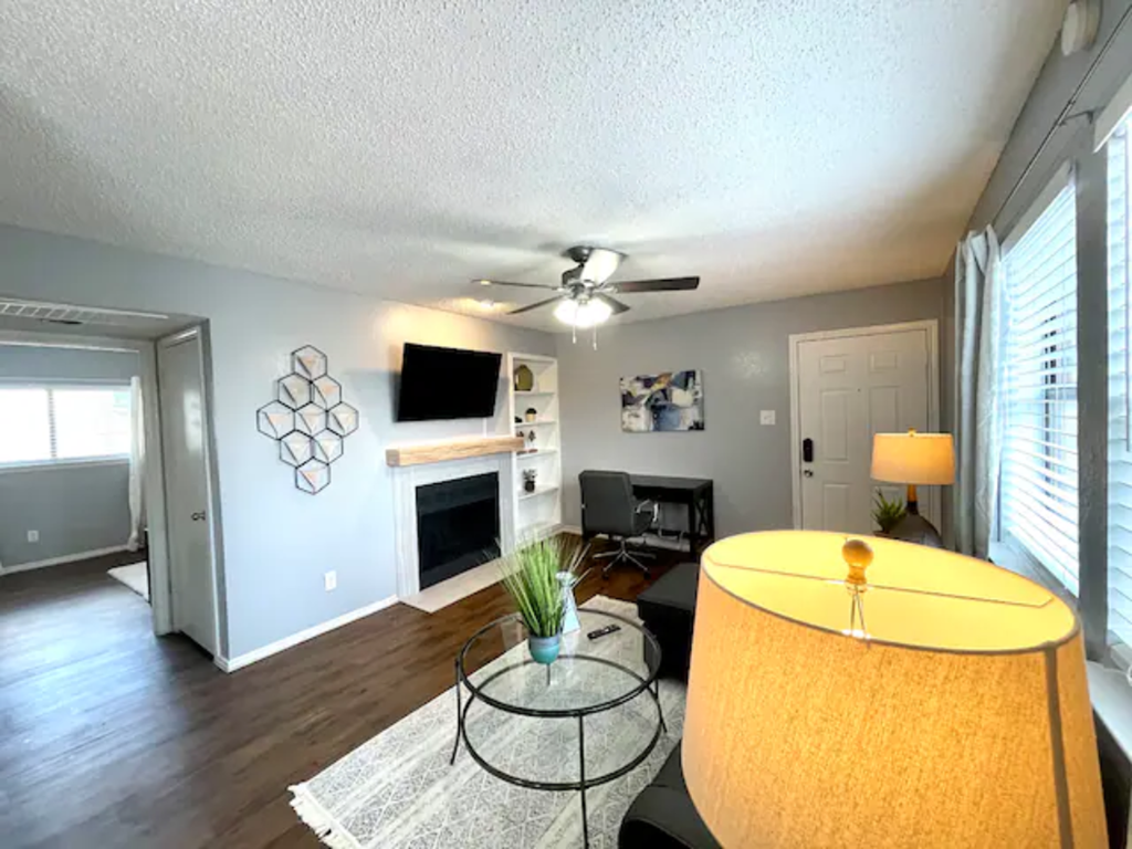 a living room with a fireplace and a ceiling fan