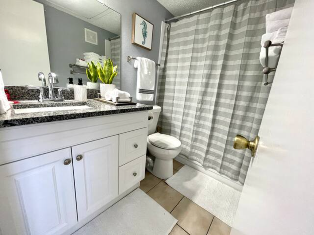 a bathroom with a toilet and a shower and a sink