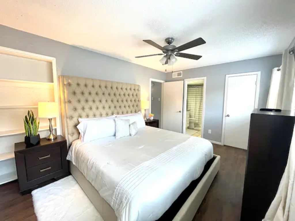 a bedroom with a large bed and a ceiling fan