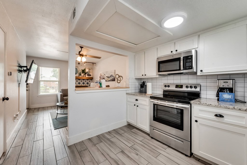a kitchen with white cabinets and stainless steel appliances