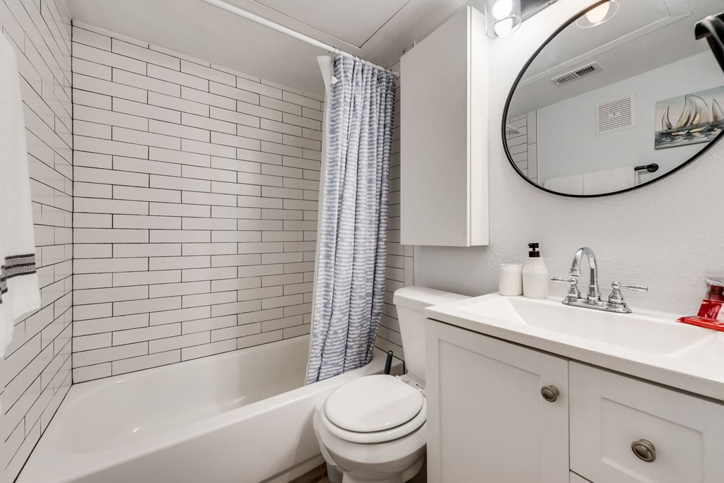 a white bathroom with a toilet sink and tub