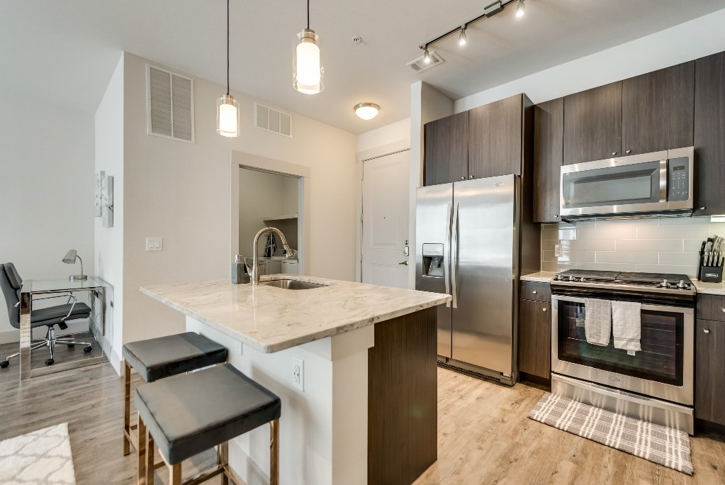 a kitchen with stainless steel appliances and a marble counter top