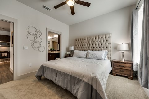 the master bedroom has a large bed and a ceiling fan