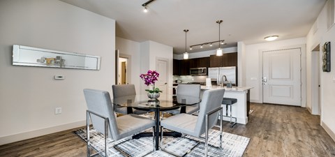 a dining room with a table and chairs and a kitchen