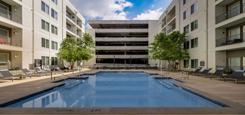 a swimming pool in the middle of two tall buildings