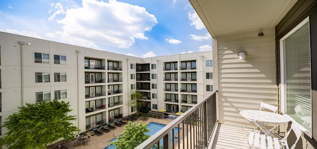 a balcony with a pool and an apartment building