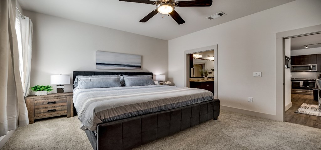 the master bedroom has a large bed and a ceiling fan