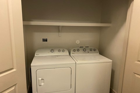 an empty laundry room with two washers and a dryer