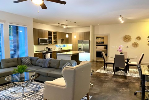 a living room and kitchen with a couch and a table