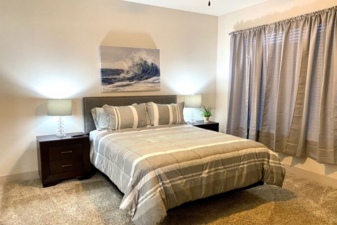 a bedroom with a bed and a painting on the wall