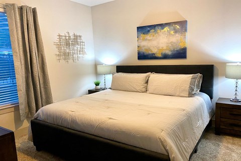 a bedroom with a bed and a painting on the wall