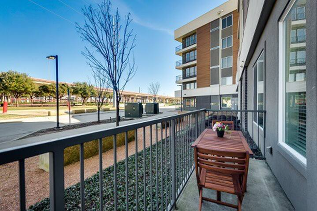 a balcony with a table and chairs next to a building