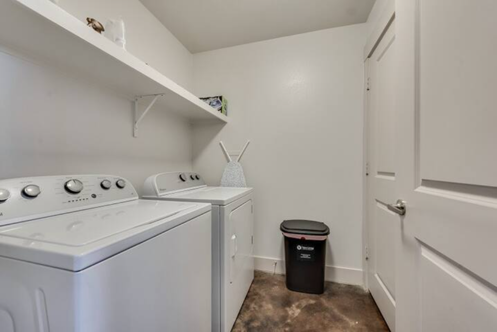 a white washer and dryer in a room with a white door