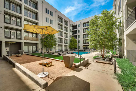 an outdoor amenities area with a pool and umbrellas in an apartment building