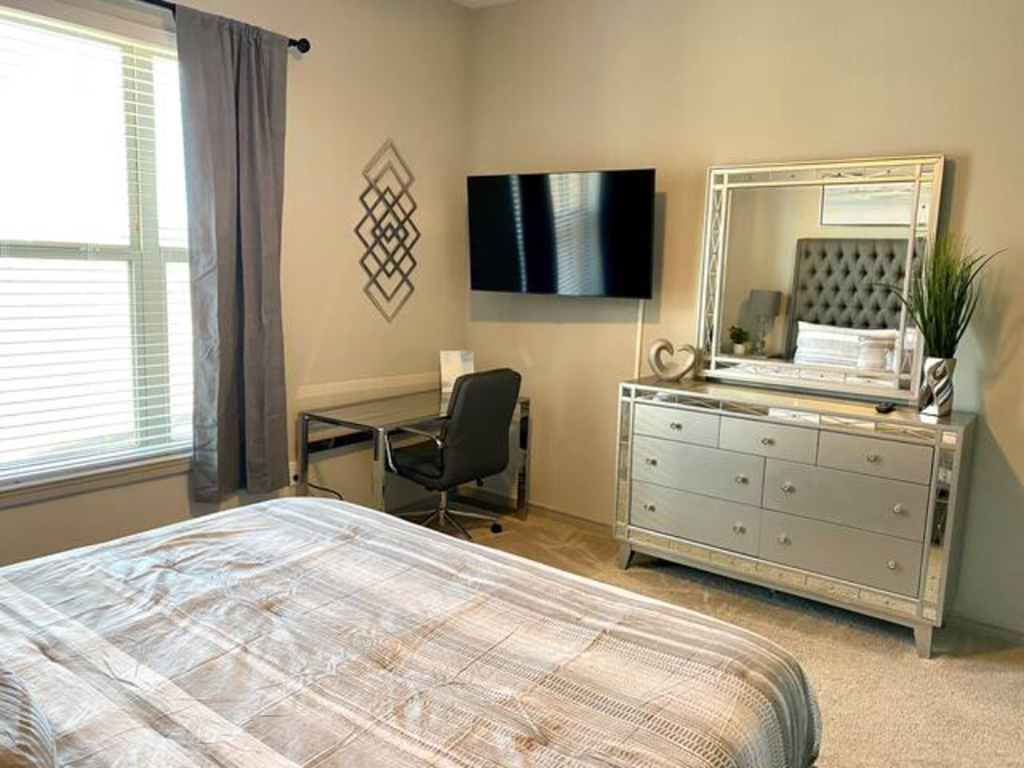 a bedroom with a bed and a dresser and a tv