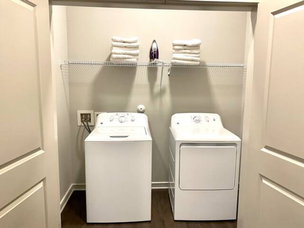 a white washer and dryer in a white laundry room